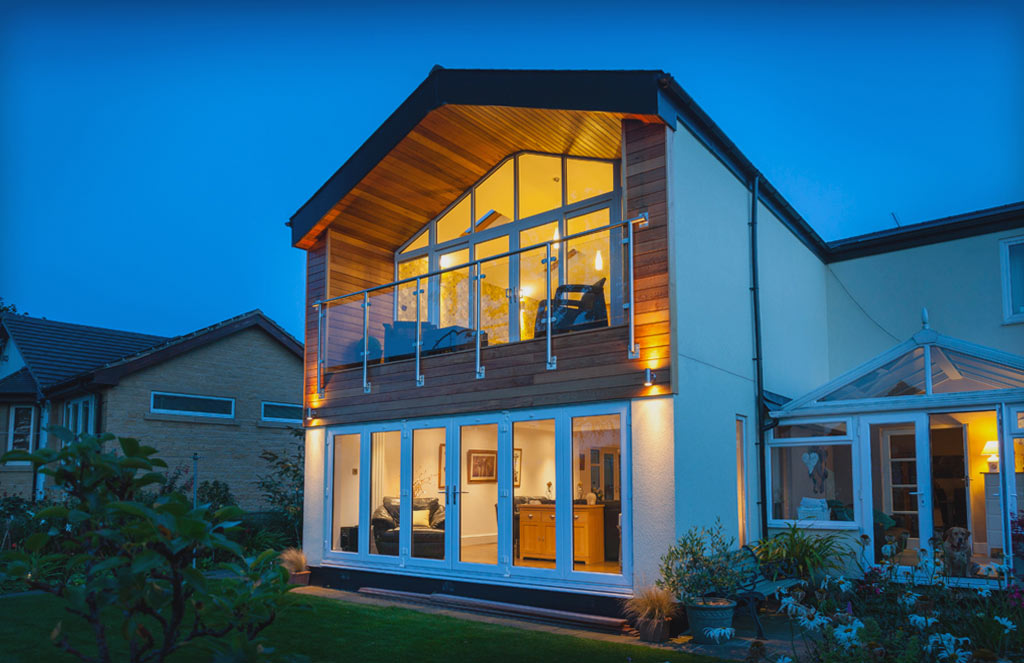 Modern house with French doors at nightime viewed from outside