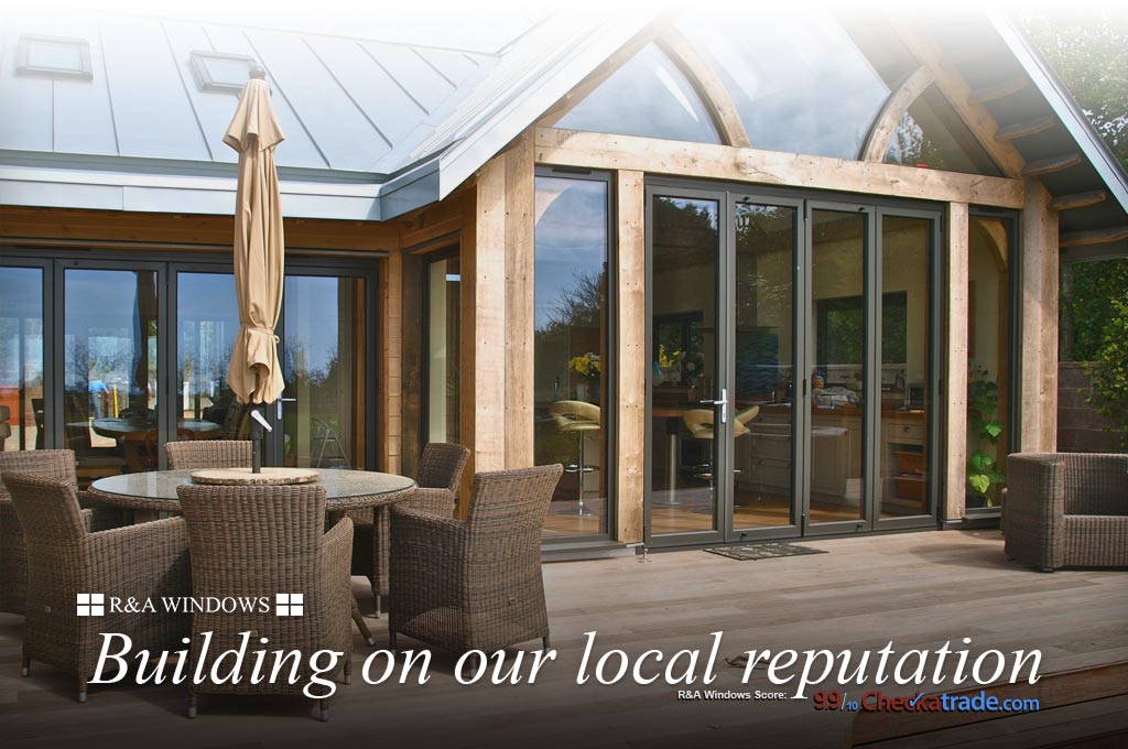 Modern bi fold-doors in thick oak frame leading out to garden decking